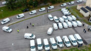 Vita skåpbilar på rad vid en parkeringsplats